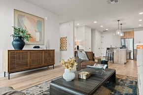 Mesa apartment for rent - A living room with a wooden cabinet and a coffee table with a vase and a plant on it.