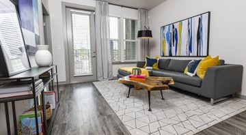 Nashville apartment for rent - A living room with a grey couch, a coffee table, and a painting on the wall.