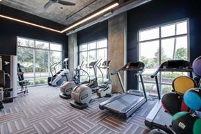 Houston apartment for rent - a gym with cardio equipment and large windows