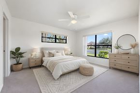 Palm Bay apartment for rent - A bedroom with a large bed, a ceiling fan, and a window with a view of the outdoors.