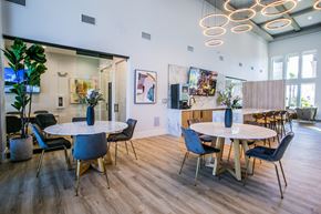 Las Vegas apartment for rent - A modern dining room with a white table and blue chairs.