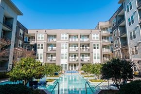 Alpharetta apartment for rent - A large apartment complex with a pool in the foreground.