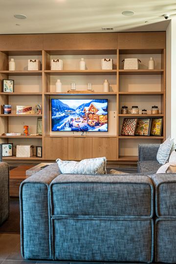 Alpharetta apartment for rent - A living room with a grey couch and a wooden entertainment unit.