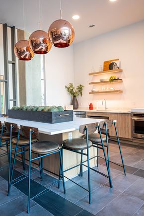 Alpharetta apartment for rent - A modern kitchen with a white island and black chairs.