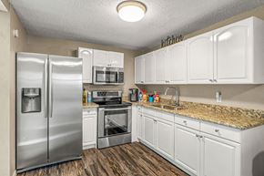 Tampa apartment for rent - a kitchen with stainless steel appliances and white cabinets