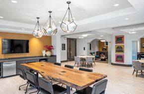 Houston apartment for rent - a conference room with a wooden table and chairs and a tv