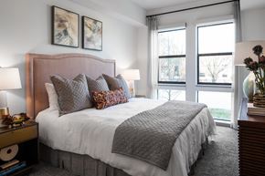 Houston apartment for rent - a bedroom with a large bed and two windows
