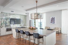 Houston apartment for rent - a kitchen with a large island with chairs and a tv