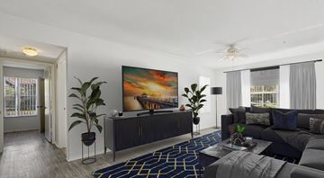Deland apartment for rent - A living room with a large painting on the wall and a dark grey sofa.