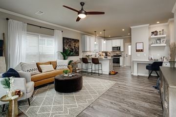 Huntsville apartment for rent - A modern living room with a white ceiling fan and a white rug on the floor.