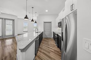 The Colony apartment for rent - A modern kitchen with a refrigerator on the right side.