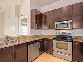 Dallas apartment for rent - A kitchen with brown cabinets and stainless steel appliances.