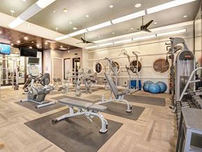 Dallas apartment for rent - A gym with a variety of equipment including treadmills, weights, and exercise balls.