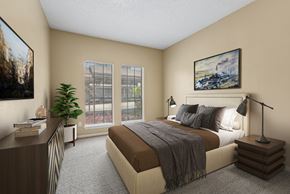 Austin apartment for rent - A bedroom with a large bed, a nightstand with a lamp, and a painting on the wall.