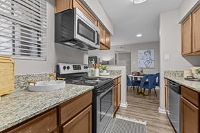 Austin apartment for rent - A kitchen with a stove top oven and microwave.