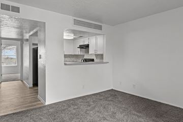 Albuquerque apartment for rent - A sparsely furnished living room with a kitchen in the background.