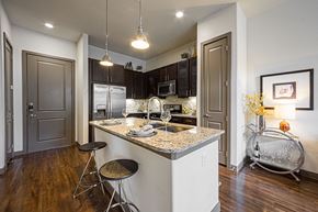 Houston apartment for rent - A kitchen with a bar stool and a counter.