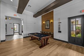 Lewisville apartment for rent - A pool table is in the middle of a room with a door to the left and a window to the right.