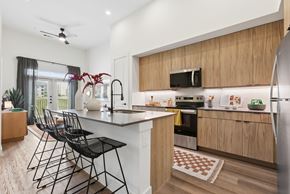 Austin apartment for rent - A kitchen with a black counter and chairs.