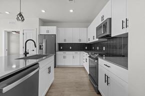 Austin apartment for rent - A modern kitchen with white cabinets and black countertops.