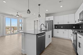 Austin apartment for rent - A modern kitchen with white cabinets and a large island.