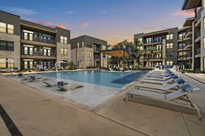 Austin townhouse for rent - A swimming pool surrounded by sun loungers and apartment buildings.