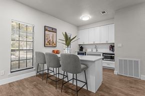 Austin apartment for rent - A kitchen with white cabinets and a wooden floor.