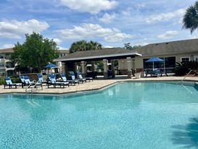 Jacksonville apartment for rent - A swimming pool with sun loungers and a building in the background.