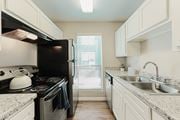 Houston apartment for rent - Kitchen With White Cabinetry And Black Appliances  at Cashel Springs, Houston, TX