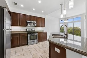 Georgetown apartment for rent - A kitchen with brown cabinets and a stainless steel refrigerator.