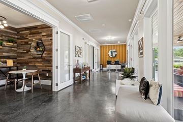 Buda apartment for rent - A modern living room with a white couch and a wooden wall.