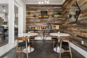 Buda apartment for rent - A modern dining area with wooden walls and tables set for two.