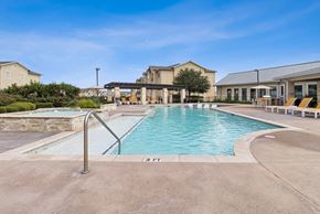 Buda apartment for rent - A swimming pool with a metal ladder and a building in the background.