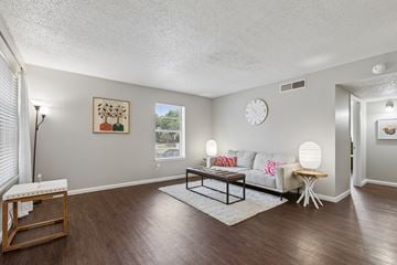 Austin apartment for rent - A living room with a white couch, a wooden coffee table, and a painting on the wall.