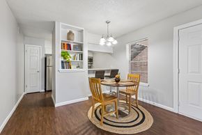 Austin apartment for rent - A dining room with a table set for two and a bookshelf filled with books.