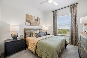 Anna apartment for rent - A bedroom with a bed, dresser, and window.