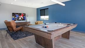 Fort Collins apartment for rent - A pool table with a chair and a painting in the background.