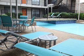 Dallas apartment for rent - a patio with tables and chairs next to a swimming pool
