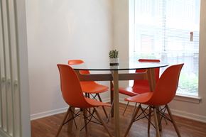 Dallas apartment for rent - a dining room with a table and four orange chairs
