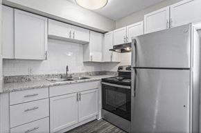 Mableton townhouse for rent - a kitchen with white cabinets and a stainless steel refrigerator