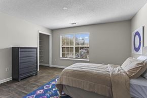 Lilburn apartment for rent - a bedroom with a bed and a dresser and a window