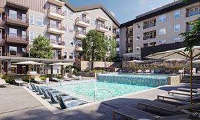 Anna apartment for rent - A large swimming pool surrounded by lounge chairs and umbrellas in front of apartment buildings.