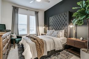 Dallas apartment for rent - a bedroom with a bed and a dresser and a window