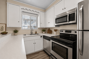 Austin apartment for rent - A modern kitchen with stainless steel appliances and white cabinets.
