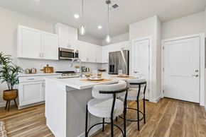 Denver townhouse for rent - A kitchen with white cabinets and a wooden floor.