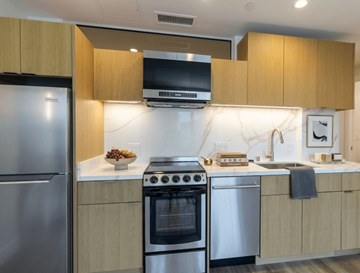 Oakland apartment for rent - A modern kitchen with stainless steel appliances and wooden cabinets.