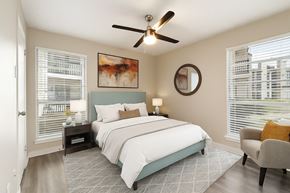 Dallas apartment for rent - A bedroom with a large bed and a ceiling fan.