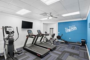 Apopka apartment for rent - A gym with treadmills, elliptical machines, and a television.