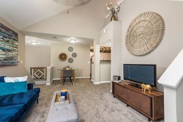 Aurora apartment for rent - A living room with a blue couch and a wooden entertainment center.