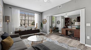 Deland apartment for rent - A modern living room with a grey sofa and a glass coffee table.